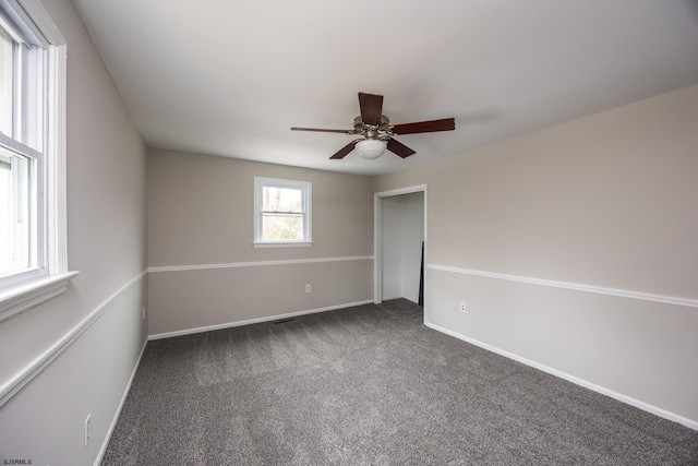 carpeted empty room with baseboards and ceiling fan