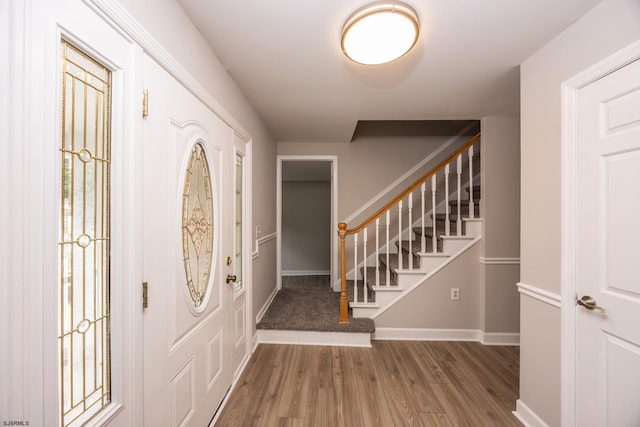 foyer featuring stairway, baseboards, and wood finished floors