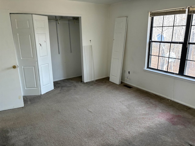 unfurnished bedroom featuring a closet, visible vents, and carpet floors