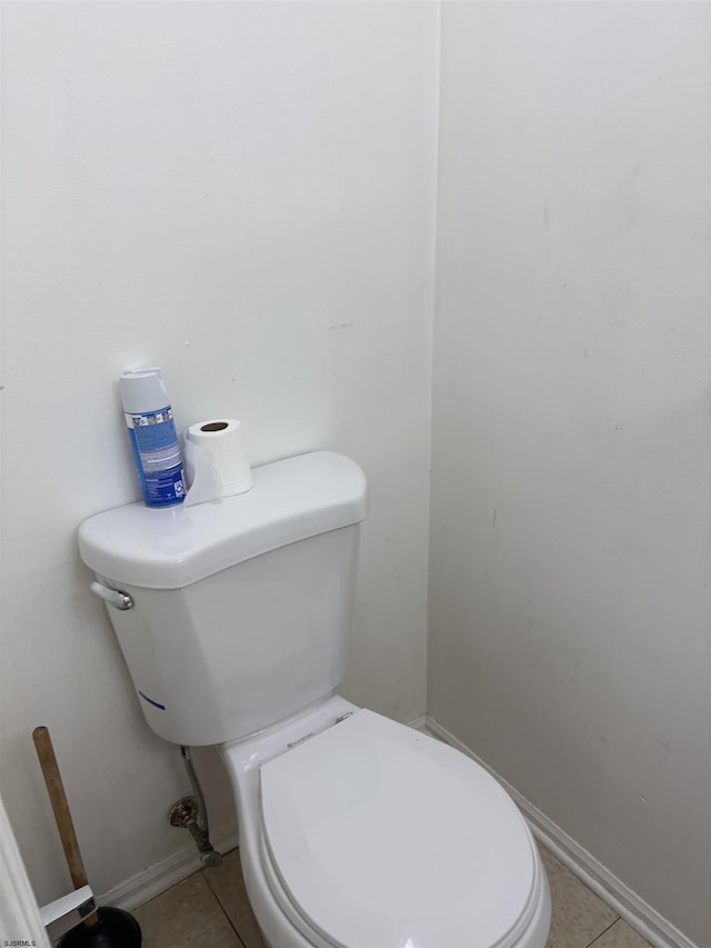 bathroom with tile patterned flooring, toilet, and baseboards