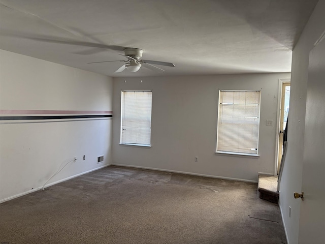 spare room with visible vents, ceiling fan, baseboards, and carpet