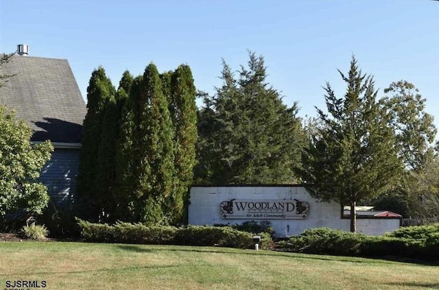 community / neighborhood sign featuring a yard