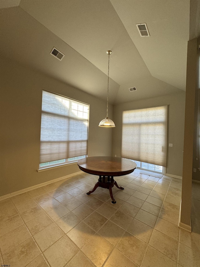 unfurnished dining area featuring visible vents, baseboards, and vaulted ceiling