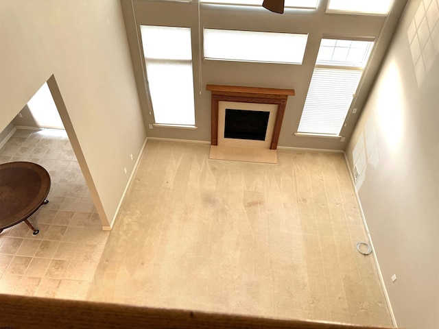 living area with baseboards and a fireplace with flush hearth