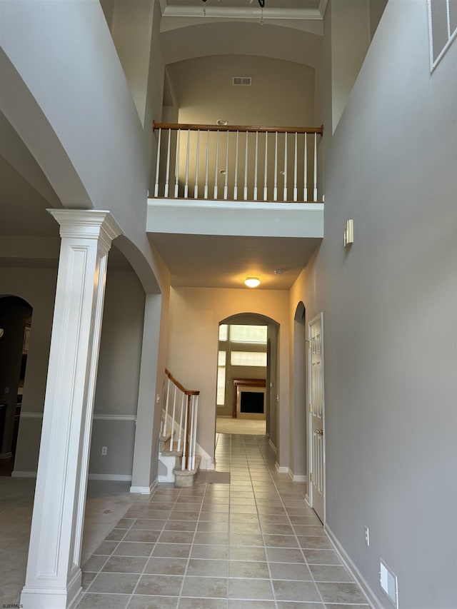 hall with visible vents, stairway, a high ceiling, tile patterned flooring, and baseboards