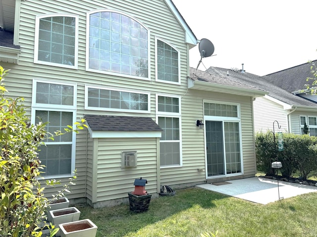 rear view of property with a patio area, a lawn, and roof with shingles