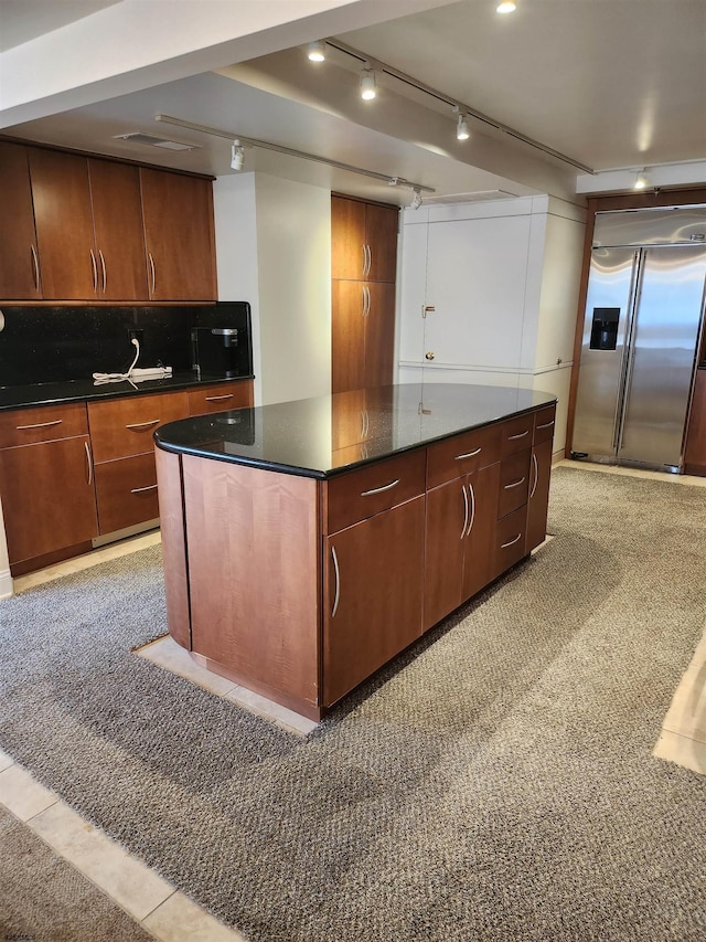 kitchen featuring decorative backsplash, a kitchen island, and stainless steel built in refrigerator