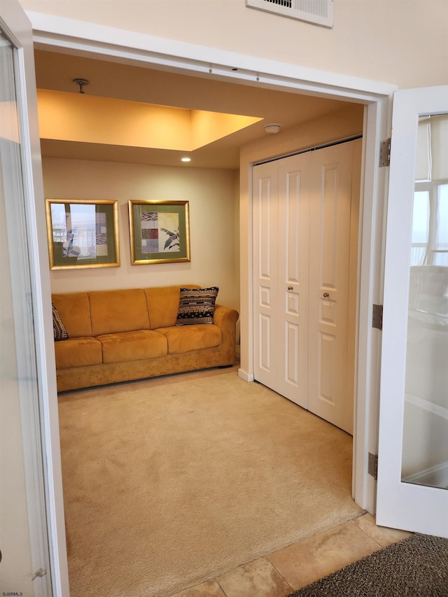 unfurnished living room featuring visible vents and light colored carpet