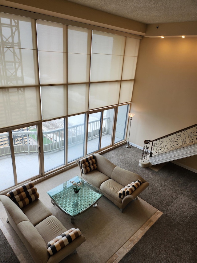 unfurnished living room featuring a textured ceiling, baseboards, and carpet floors