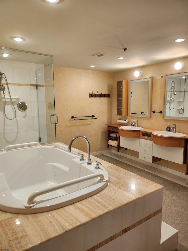 full bathroom featuring visible vents, a shower stall, double vanity, a bath, and a sink