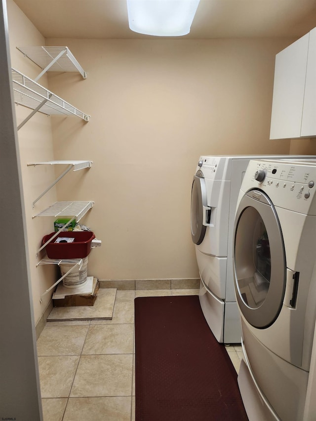 laundry area featuring washer and dryer, baseboards, laundry area, and light tile patterned floors