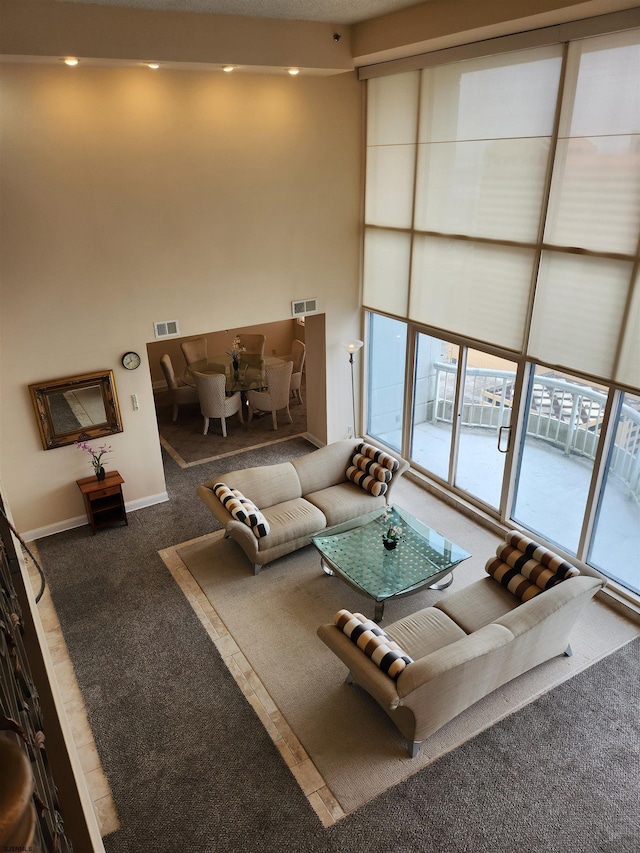 unfurnished living room with carpet flooring, baseboards, and visible vents