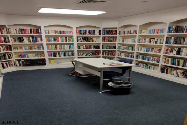 interior space featuring visible vents, carpet, and bookshelves