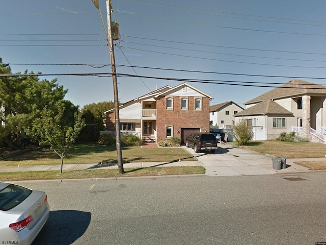 view of front of property featuring driveway, brick siding, a front lawn, a garage, and a residential view