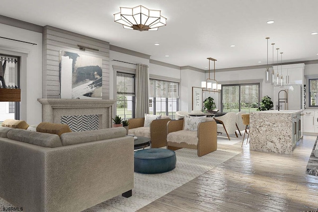 living area with a wealth of natural light, light wood-style floors, a fireplace, and recessed lighting