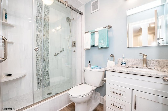 bathroom with vanity, toilet, visible vents, and a stall shower