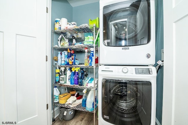 laundry area featuring laundry area, stacked washer / drying machine, and wood finished floors