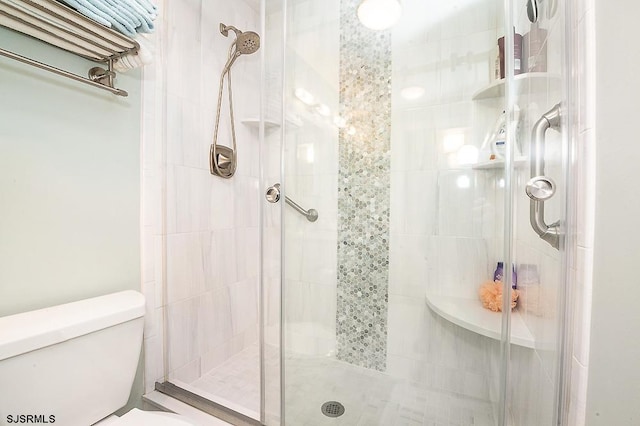 bathroom featuring a shower stall and toilet