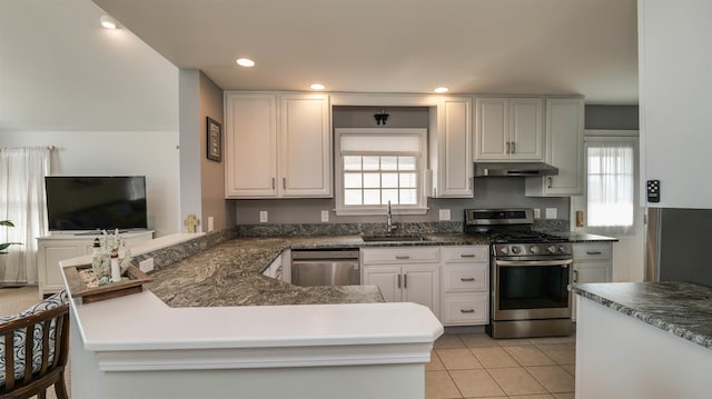 kitchen featuring under cabinet range hood, light tile patterned floors, a peninsula, stainless steel appliances, and a sink