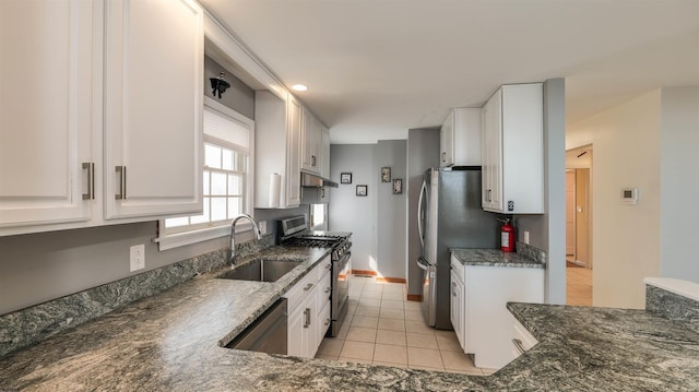 kitchen with under cabinet range hood, a sink, appliances with stainless steel finishes, white cabinets, and light tile patterned floors