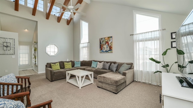 living room with baseboards, a ceiling fan, light colored carpet, and high vaulted ceiling