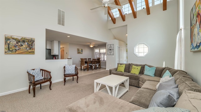 living room with visible vents, baseboards, ceiling fan, light colored carpet, and a towering ceiling