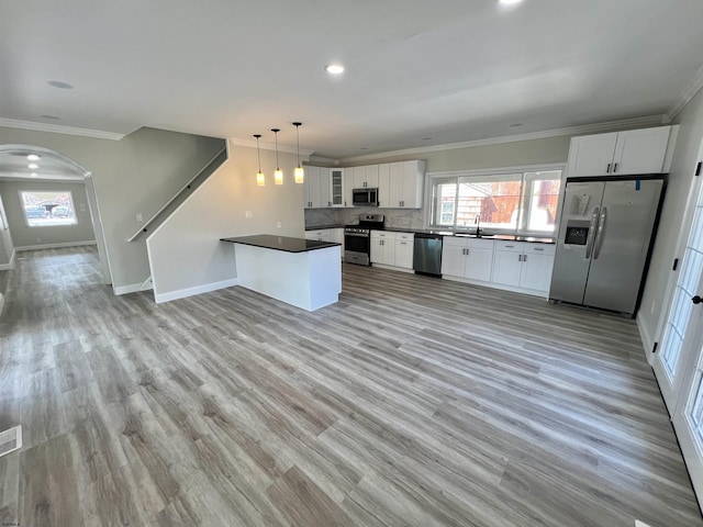 kitchen featuring a sink, dark countertops, ornamental molding, and stainless steel appliances