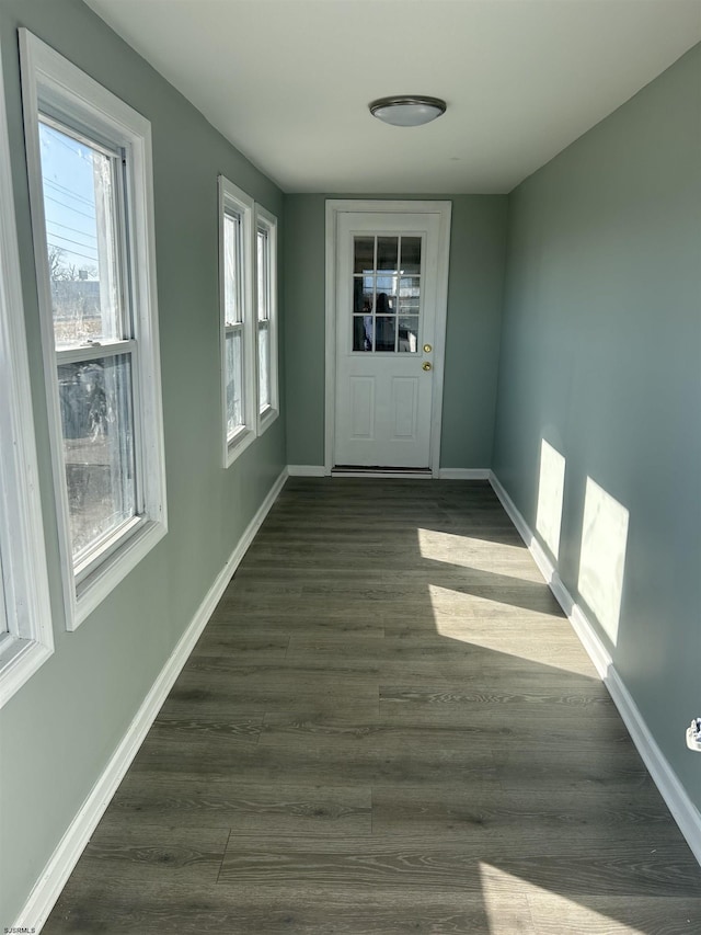 doorway to outside with dark wood finished floors and baseboards