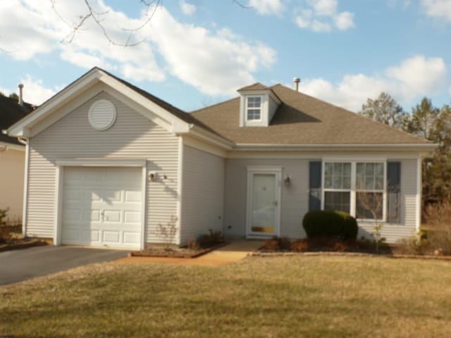 view of front of home featuring a front lawn, an attached garage, and aphalt driveway