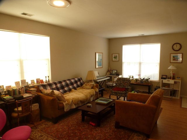 living area with wood finished floors and visible vents