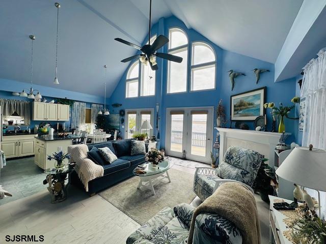 living area featuring french doors, high vaulted ceiling, and a ceiling fan