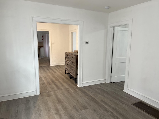interior space with dark wood finished floors, visible vents, and baseboards