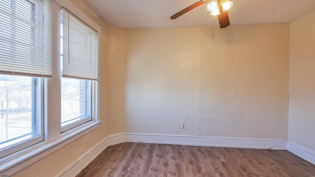 spare room featuring wood finished floors, baseboards, and ceiling fan