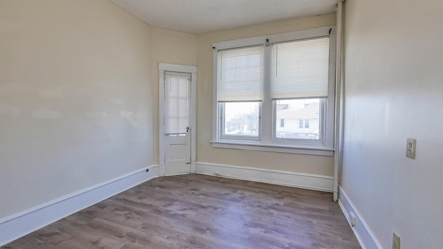 unfurnished room with baseboards and wood finished floors