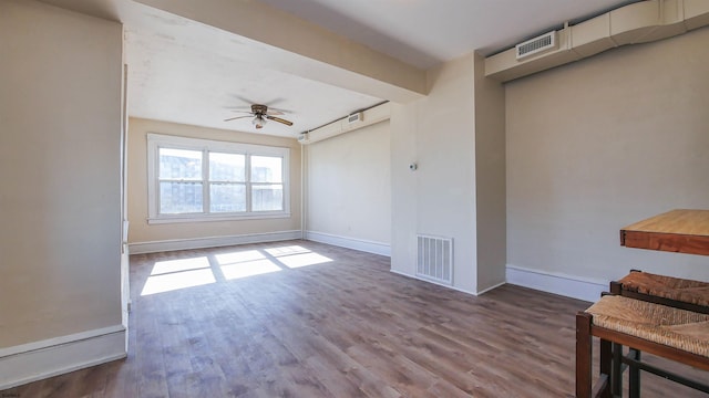 interior space featuring visible vents, ceiling fan, baseboards, and wood finished floors