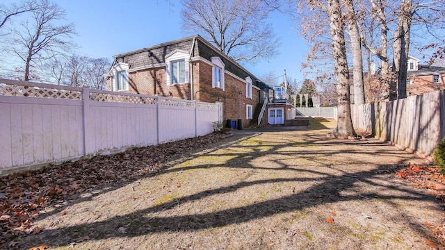 102 Morris Ave, Linwood, NJ 08221 - view of side of property featuring mansard roof, brick siding, a fenced backyard, and a lawn