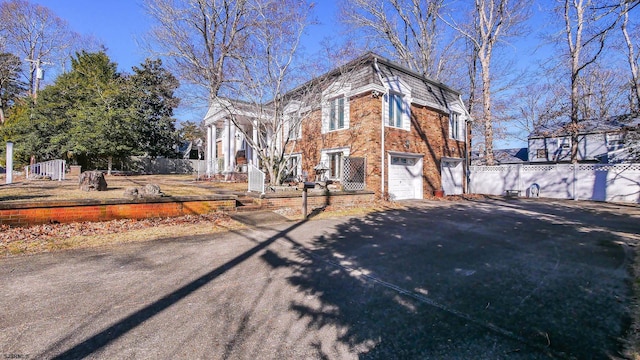 102 Morris Ave, Linwood, NJ 08221 - view of front facade with driveway, brick siding, an attached garage, and fence