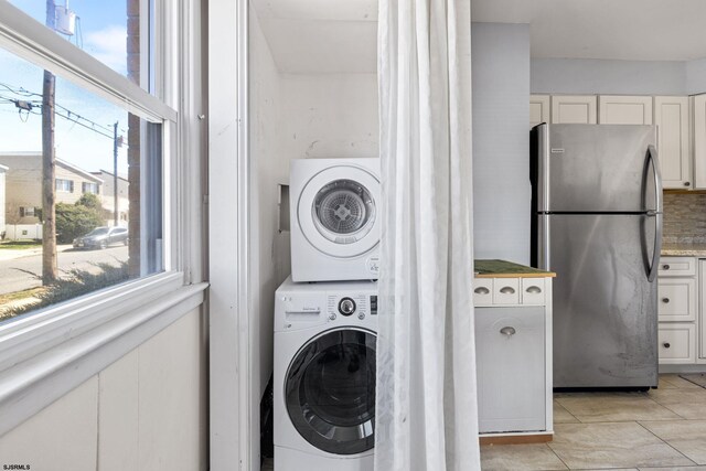 washroom featuring stacked washer and clothes dryer