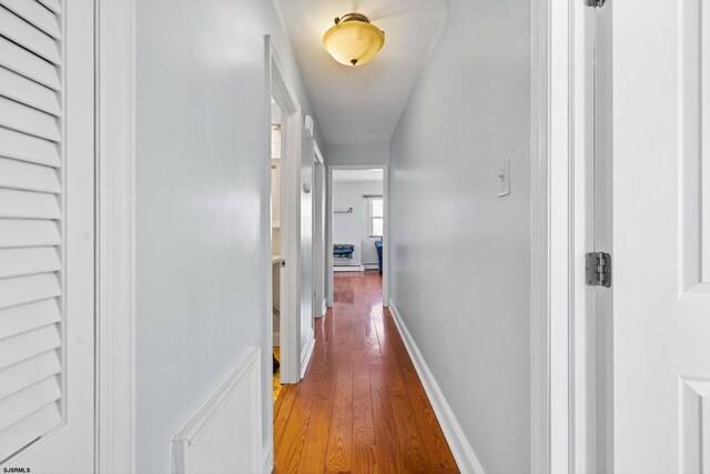 hallway featuring baseboards and wood finished floors