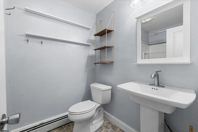 bathroom with a sink, a baseboard heating unit, baseboards, and toilet