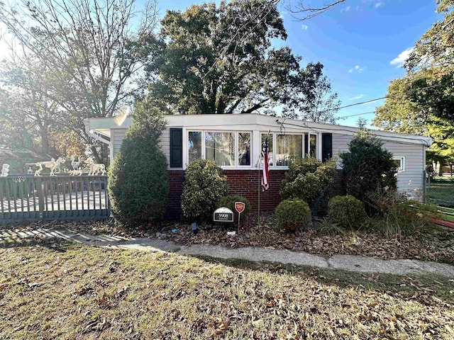 view of front of house featuring brick siding and fence