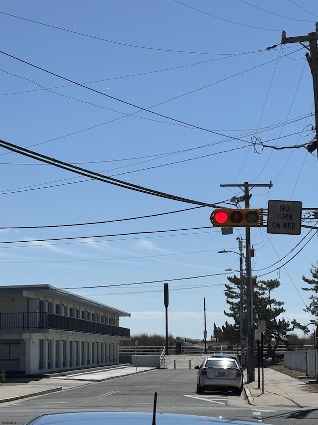 view of street with sidewalks, traffic lights, traffic signs, and curbs