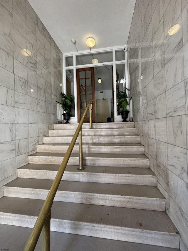 stairs featuring tile walls