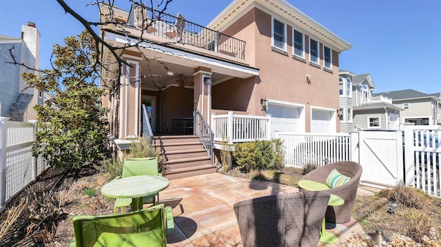 1905 Glenwood Dr, Ocean City, NJ 08226 - back of house featuring stucco siding, a gate, fence, a balcony, and an attached garage