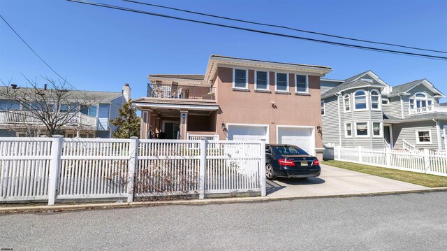 1905 Glenwood Dr, Ocean City, NJ 08226 - view of front of home with driveway, a balcony, a garage, stucco siding, and a fenced front yard