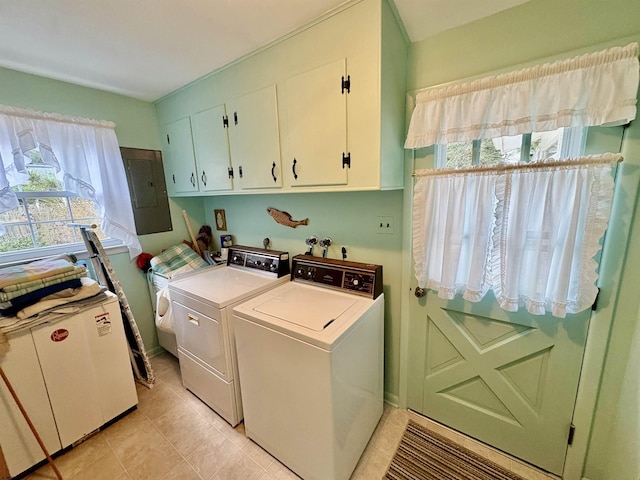 washroom with electric panel, washer and clothes dryer, light tile patterned flooring, and cabinet space