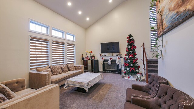 carpeted living area featuring a glass covered fireplace, high vaulted ceiling, stairs, and recessed lighting