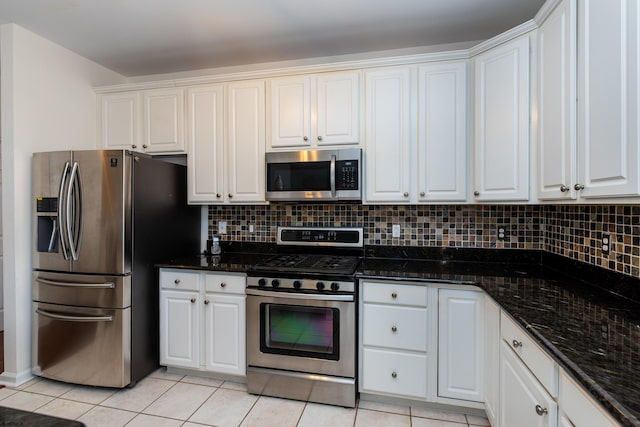 kitchen featuring backsplash, appliances with stainless steel finishes, light tile patterned floors, and white cabinetry