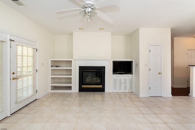 unfurnished living room with visible vents, baseboards, ceiling fan, light tile patterned flooring, and a glass covered fireplace