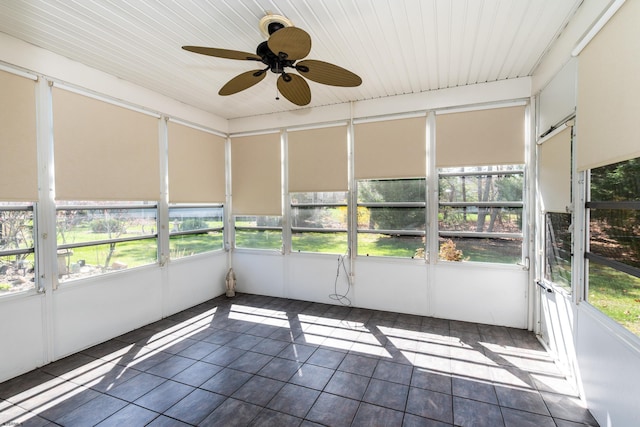 unfurnished sunroom featuring ceiling fan and a wealth of natural light